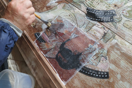 絵馬の絵具が剥落するのをとめるため、専門の和紙の上から剥落とめの溶液を塗ります。